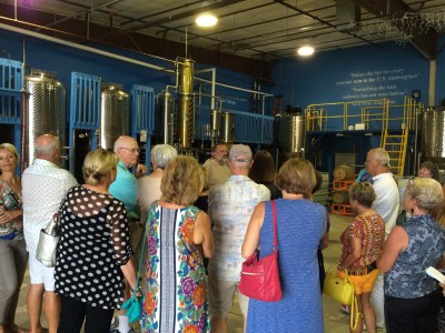 Group of tour participants listening to tour guide at Drum Circle Distillery
