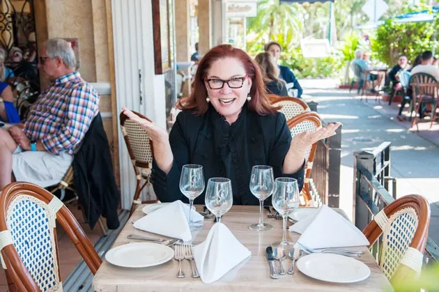Susan Robinson, Owner of Key Culinary Tours posing at dinning table in Sarasota, FL