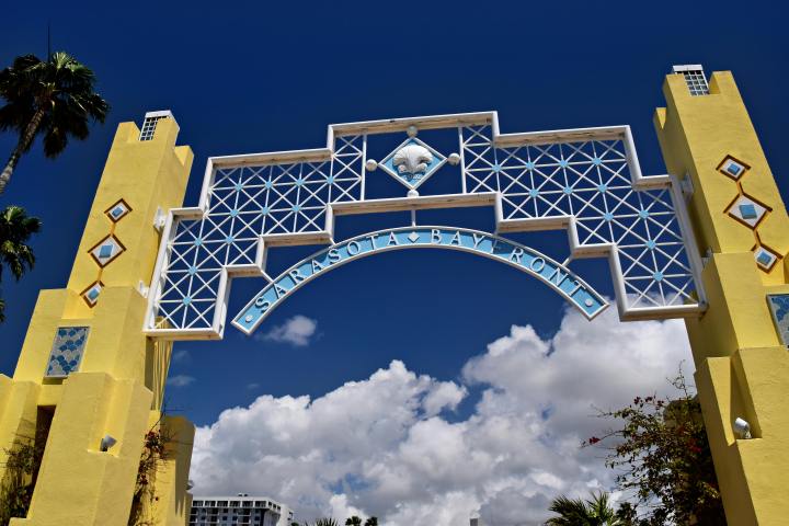 Sarasota Bayfront entrance with yellow pillars and blue sky.